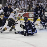 golden knights and winnipeg jets scuffling in front of the net on a failed scoring attempt by the Golden Knights