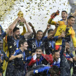 france celebrates winning the world cup while hoisting the trophy amidst a confetti filled stadium