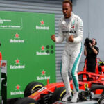 British driver Lewis Hamilton celebrates atop his Mercedes race car after winning the Italian Grand Prix in Monza, Italy