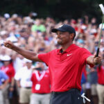 tiger woods raising his putter in the air after finishing the 18th hole on sunday at east lake winning his first pga championship in five years.