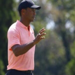 tiger woods waves to crowds after sinking a 25 foot putt on the 18th hole at east lake head