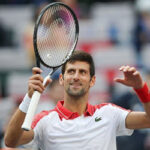 nadal djokovic raises his racket to supporters on saturday after defeating alexander zverev in back-to-back sets to advance to the finals on sunday.