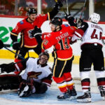 calgary's matthew tkachuk celebrates after scoring in the second period as coyotes goalie adam hill looks up in dispair