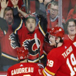 calgary flame fans celebrate with johnny gaudreau and matthew tkachuk after the tkachuk scored his second goal of the game.