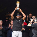 kawhi leonard hoists the championship trophy above his head during ceremony celebrations in toronto on monday.