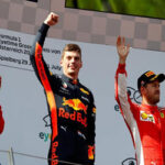max verstappen raises his fist on the podium after finishing first to the crowds at sunday's austrian grand prix