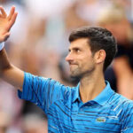 Novak Djokovic waves to the crowd after winning his first round match against Roberto Carballes Baena on Monday at the Arthur Ashe Stadium in New York.